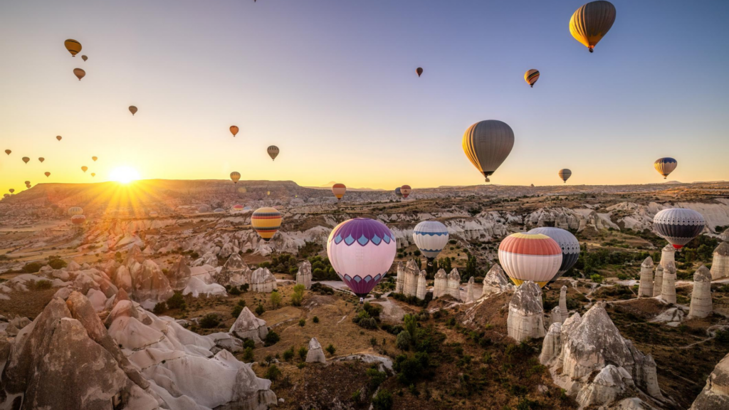 Cappadocia hot air balloons flying over fairy chimneys at sunrise in Turkey